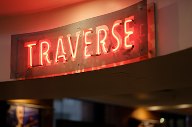 Neon sign reading 'TRAVERSE'.