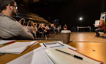 A workshop in our large Traverse 1 performance space. A note book is lying open on a table.